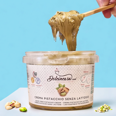 Secchiello di crema al pistacchio senza lattosio Dolcincasa con spatola che solleva la crema, su sfondo azzurro